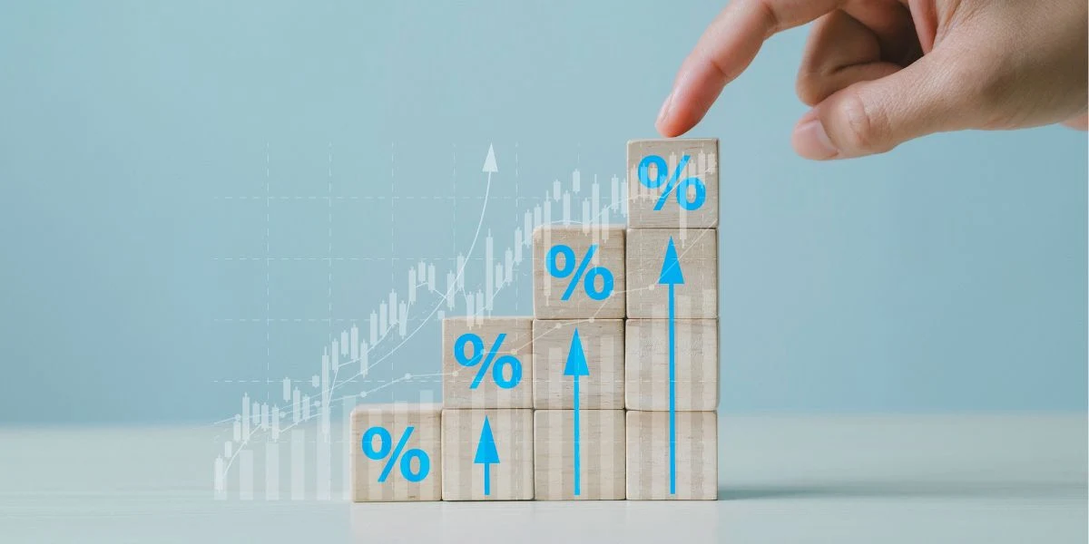 Dedo apontando para um gráfico em crescimento representado por blocos de madeira