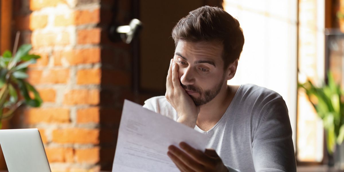 homem lendo documento impresso em papel