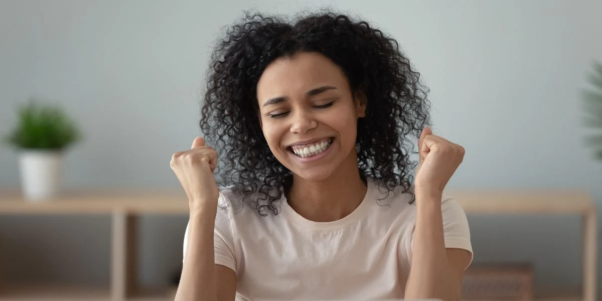 Mulher sorridente fazendo gesto de comemoração